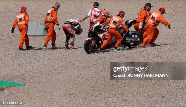 Honda LCR Japanese rider Takaaki Nakagami with marshall staff after crashing during the qualifying session of the MotoGP German motorcycle Grand Prix...