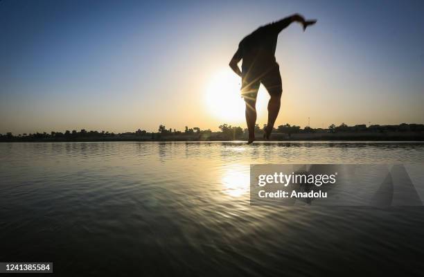 People jump into Tigris River to cool off during extreme hot weather in Baghdad, Iraq on June 18, 2022.