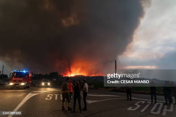 Firefighters, police officers and residents look on as a wildfire rages in Pumarejo de Tera near Zamora, northern Spain, on June 18, 2022. -...
