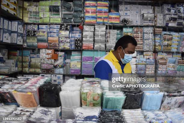 Shop owner awaits for customers while selling protective masks at the San Salvador Historical Center on June 18, 2022 in San Salvador, El Salvador....