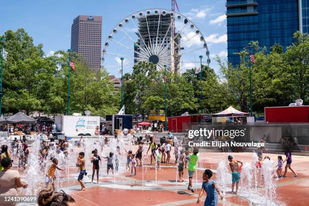 Children play in a fountain at Centennial Olympic Park during a Juneteenth celebration on June 18, 2022 in Atlanta, United States.Juneteenth, or...