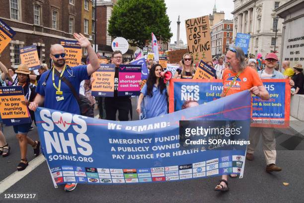 Protesters hold a banner and placards in support of the NHS and fair pay for nursing staff during the demonstration in Whitehall. Thousands of people...