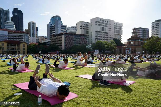 Hundreds of people participate in a yoga exercise at Srinakharinwirot University field, marking the International Day of Yoga in Bangkok, Thailand....