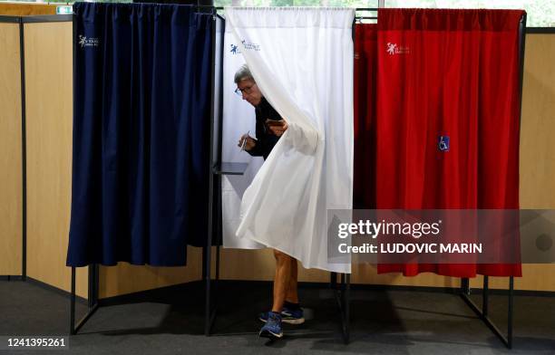 Man leaves a booth after voting in the second stage of French parliamentary elections at a polling station in Le Touquet, northern France on June 19,...