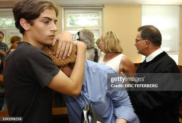 Roman Kolinka , un des fils de Marie Trintignant, étreint sa grand-mère Nadine Trintignant, dans la salle d'audience du tribunal de Vilnius, le 31...