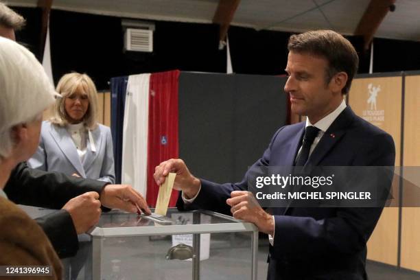 France's President Emmanuel Macron casts his ballot next to his wife Brigitte Macron during the second stage of French parliamentary elections at a...