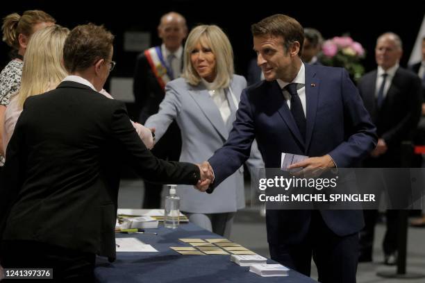 French President Emmanuel Macron and his wife Brigitte Macron arrive to vote in the second stage of French parliamentary elections at a polling...