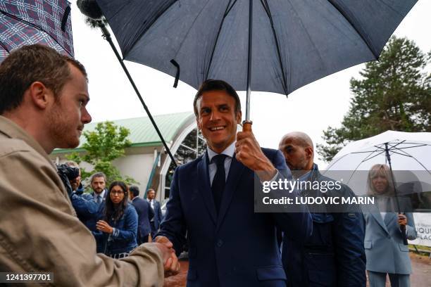 France's President Emmanuel Macron speaks with onlookers as he leaves after casting his vote in the second stage of French parliamentary elections at...