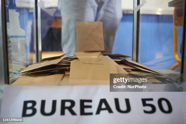 Ballot paper falls in the urn after a voter carries his vote. For the second round of the French legislative elections, people go to the polling...