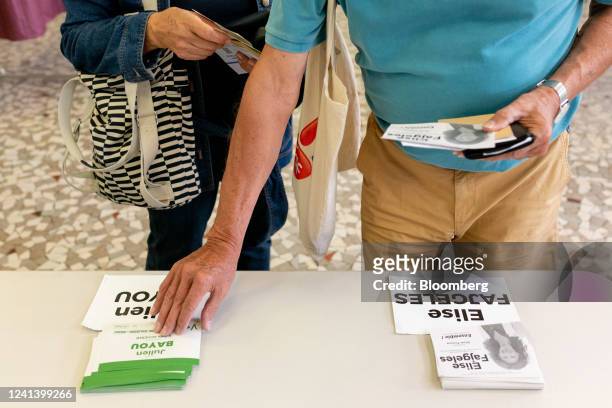 Voters collect voting information at a polling station during the second round of voting in parliamentary elections, in Paris, France, on Sunday,...