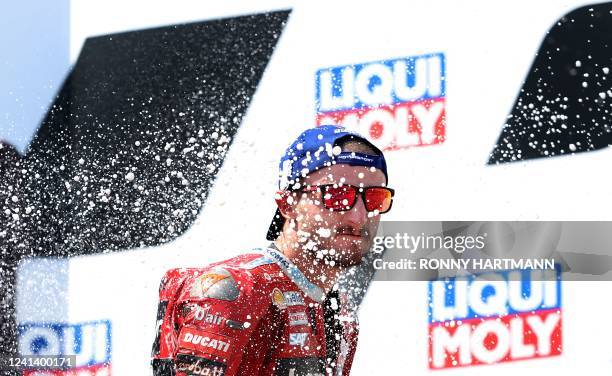 Third placed Ducati Lenovo's Australian rider Jack Miller celebrates on the podium after the German MotoGP Grand Prix at the Sachsenring racing...