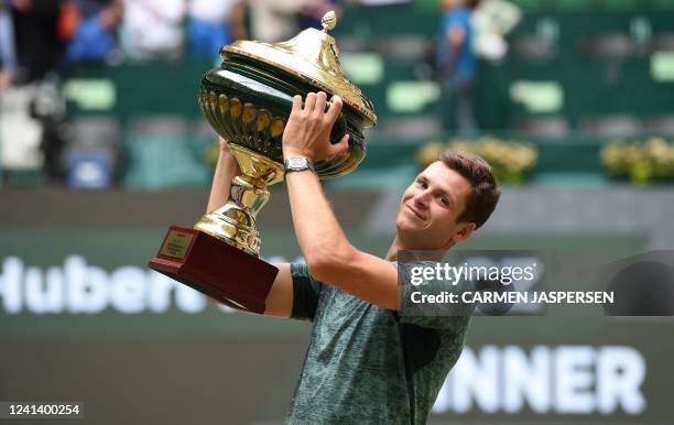 Poland's Hubert Hurkacz celebrates with the trophy after winning his singles final match against Russia's Daniil Medvedev at the ATP 500 Halle Open...