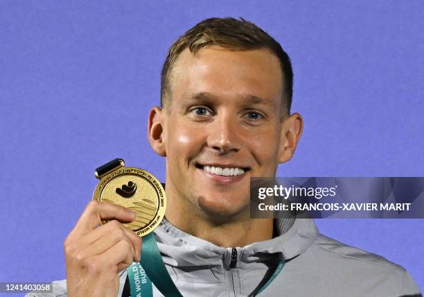 Gold medallist USA's Caeleb Dressel poses with their medal following the men's 50m butterfly finals during the Budapest 2022 World Aquatics...