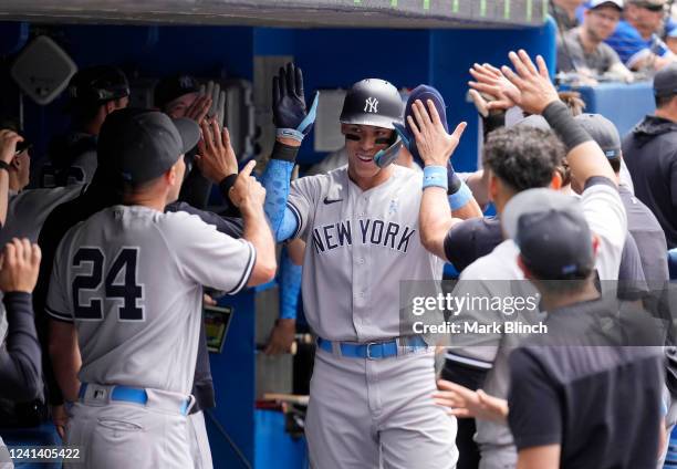 Aaron Judge of the New York Yankees celebrates scoring in the dugout against the Toronto Blue Jays in the fifth inning during their MLB game at the...