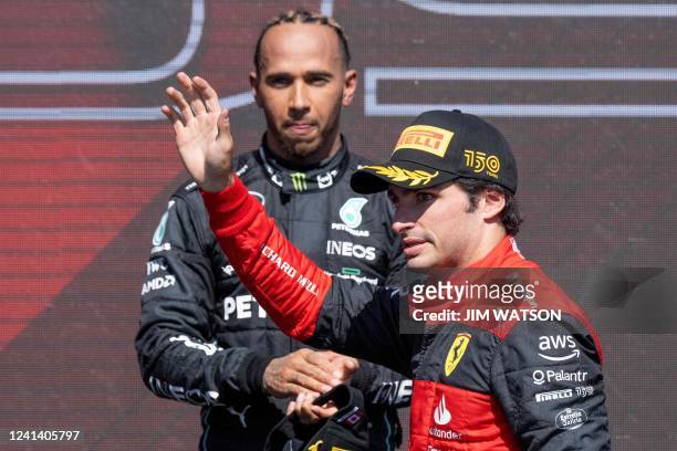 Ferrari's Spanish driver Carlos Sainz Jr celebrates on the podium with Mercedes' British driver Lewis Hamilton after the Canada Formula 1 Grand Prix...