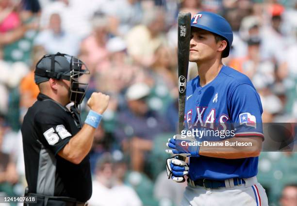Corey Seager of the Texas Rangers heads for the dugout with home plate umpire Jansen Visconti making the strikeout call during the seventh inning at...