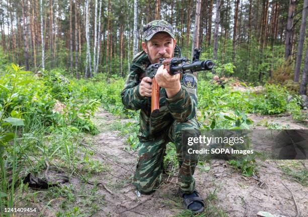Territorial defense fighter with a machine gun is in a combat position during combat training. Dozens of Bucha Territorial Defense members performed...