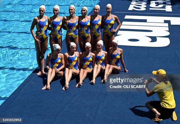 Members of Ukraine's Artistic Swimming team pose for a photograph wearing swimsuits with the words 'Stop War' and an image depicting a white dove...