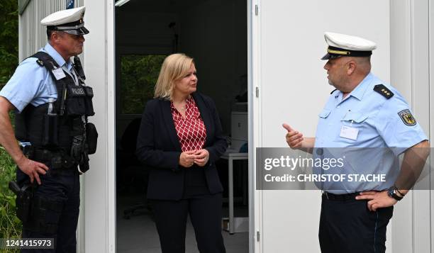 German Interior Minister Nancy Faeser speaks with police officers during her visit to inform herself about security measures at a police border...