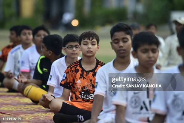 Youth take part in a yoga practice session on the eve of International Yoga Day, in Allahabad on June 20, 2022.