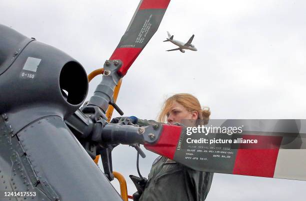 June 2022, Brandenburg, Schönefeld: A mechanic from the German Air Force services the tail rotor of a helicopter at the International Aerospace...