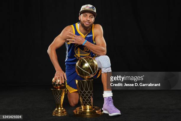 Stephen Curry of the Golden State Warriors poses with the The Bill Russell NBA Finals Most Valuable Player Award and the Larry O'Brien NBA...