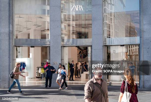 Pedestrians walk past the Spanish multinational clothing design retail company by Inditex, Zara, store in Spain.
