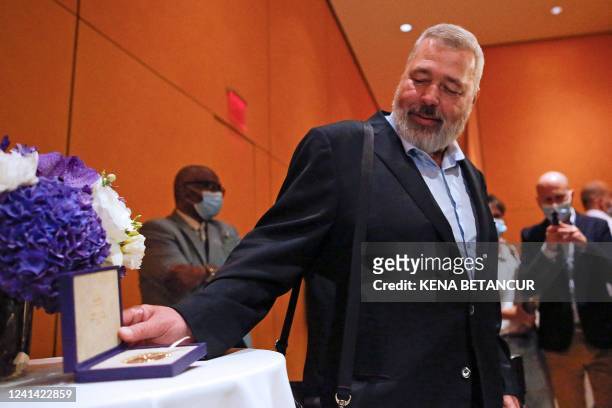 Russian journalist Dmitry Muratov pose to members of the media as he attends an event before the auctioning his Nobel Peace Prize medal to support...
