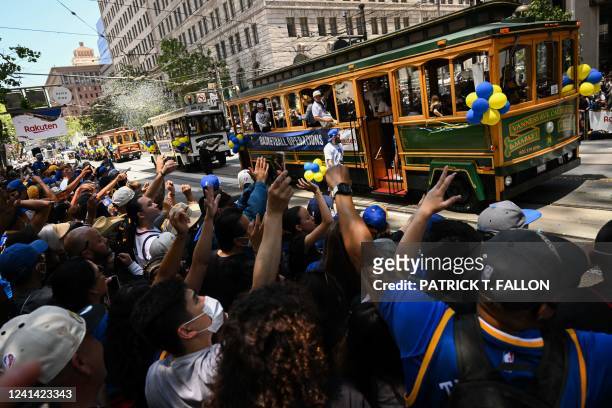 Basketball fans cheer during the Golden State Warriors NBA Championship victory parade along Market Street in San Francisco, California on June 20,...