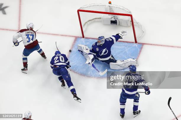 Goalie Andrei Vasilevskiy of the Tampa Bay Lightning stretches to make a save against J.T. Compher of the Colorado Avalanche during the first period...