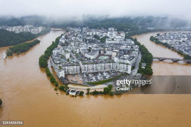 This aerial photo taken on June 20, 2022 shows flooded streets and buildings following heavy rains in Wuyuan, in China's central Jiangxi province. -...