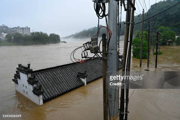 This photo taken on June 20, 2022 shows flooded streets and buildings following heavy rains in Wuyuan, in China's central Jiangxi province. - China...