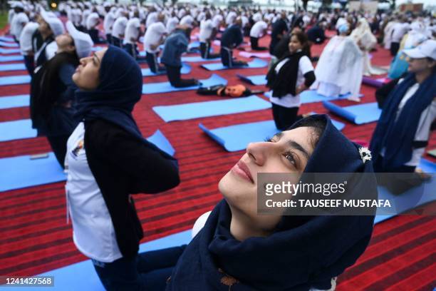 People participate in a mass yoga session near the Dal Lake to celebrate the International Day of Yoga in Srinagar on June 21, 2022.