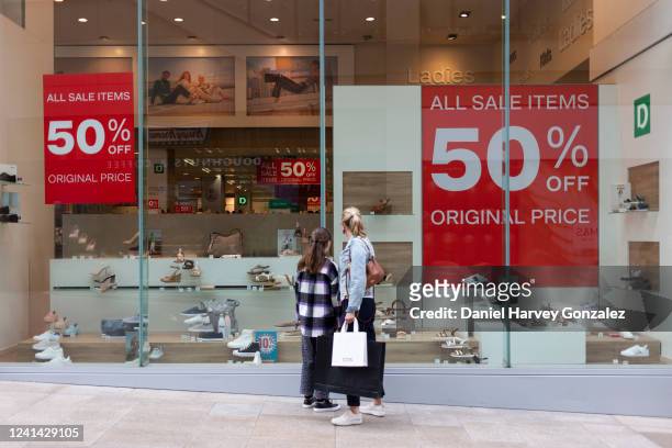 Shoppers browse the half price sale window displays of Deichmann, a high street retailer of fashion footwear, as expert economic forecast warns the...