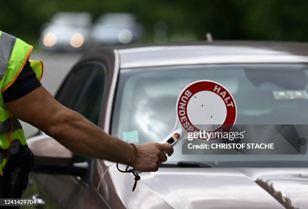 Police officer stops a car at a police border control station near Garmisch-Partenkirchen, southern Germany on June 20 a few days ahead of the start...