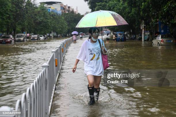 Resident walks on a flooded street after heavy rains in Shaoguan in China's southern Guangdong province on June 21, 2022. - China OUT / China OUT