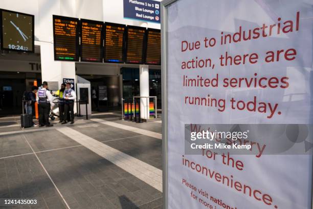 Sign announcing apologies for inconvenience due to strike action inside a quiet Grand Central / New Street station which is open but running a...