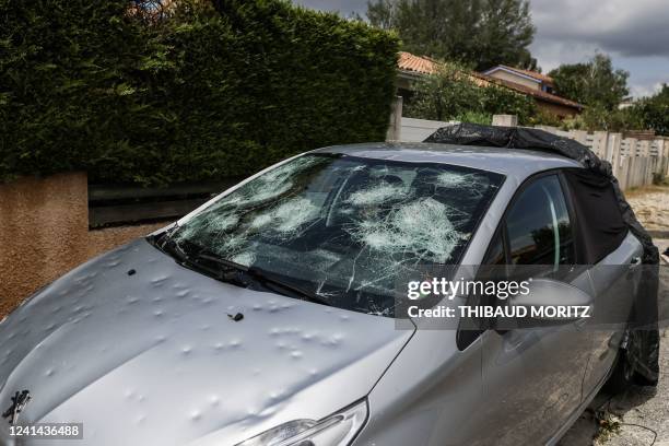 This photo taken on June 21 shows a damaged car with a broken windscreen as an aftermath of a hailstorm hit the area. - The climatic episode hit, in...