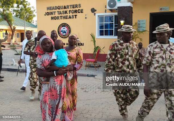 Kidnapped Chibok schoolgirls Hauwa Joseph and Mary Dauda carry their babies as they arrive accompanied by soldiers at Maimalari Barracks in...