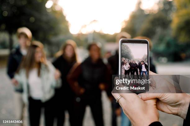 cropped hands of woman with smart phone filming teenagers dancing on street in city - filming 個照片及圖片檔