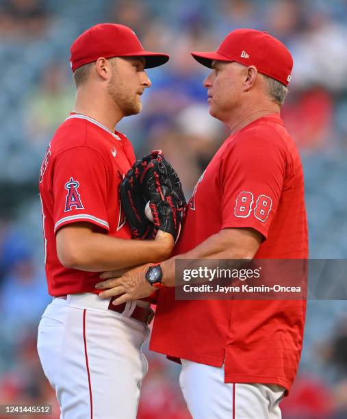 Interim manager Phil Nevin of the Los Angeles Angels talks with starting pitcher Reid Detmers on the mound in the second inning of the game against...