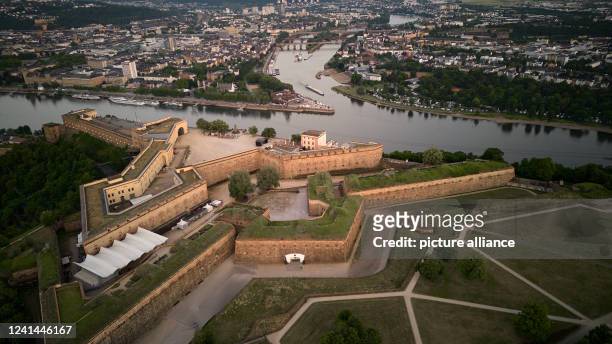 June 2022, Rhineland-Palatinate, Koblenz: The sun rises over Ehrenbreitstein Fortress. The fortress complex is located high above the German Corner...