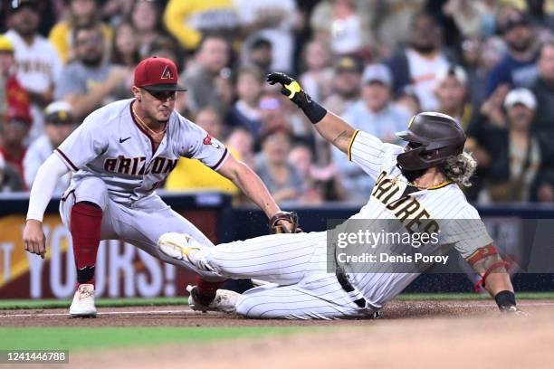 Luke Voit of the San Diego Padres is tagged out at third base by Josh Rojas of the Arizona Diamondbacks during the sixth inning of a baseball game...