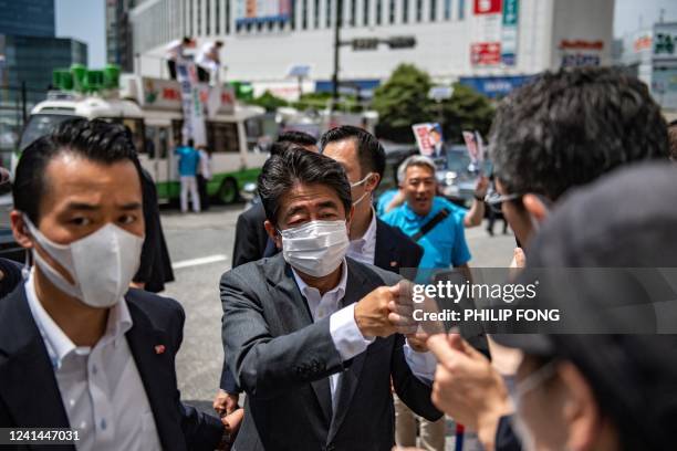 Former Japanese prime minister Shinzo Abe interacts with supporters as he joins the election campaign for Liberal Democratic Party member Kentaro...