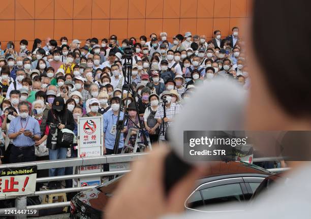 Voters listen to an election campaign speech on the first official day of campaigning ahead of the House of Councillors election on July 10, in Tokyo...