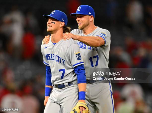 Bobby Witt Jr. #7 and Hunter Dozier of the Kansas City Royals smile after defeating the Los Angeles Angels in the 11th inning of the game at Angel...