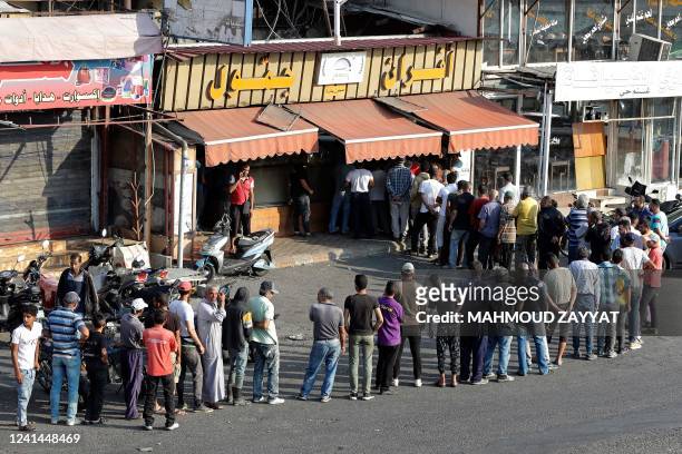 People line up in front of a bakery to buy bread in Lebanon's southern city of Sidon on June 22, 2022 as fuel and wheat shortage deepens. - Lebanon...
