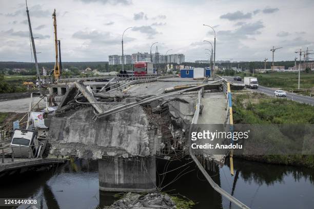 Vehicles drive by a bridge that was destroyed in Irpin on last February during the fighting between Ukrainian forces with Russian troops, Irpin,...