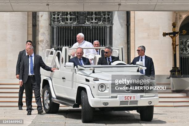 Pope Francis, escorted by his bodyguards and aides, leaves in the popemobile car at the end of the weekly general audience on June 22, 2022 at St....