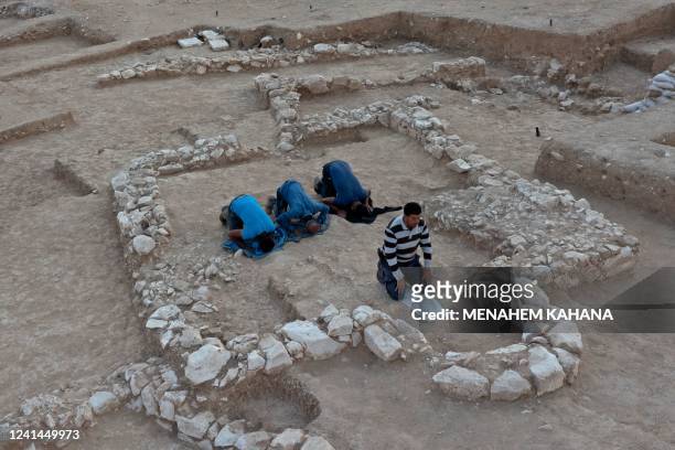 Muslim Palestinian workers of Israel's Antiquities Authority pray amid the remains of a recently discovered ancient mosque, which dates back to the...